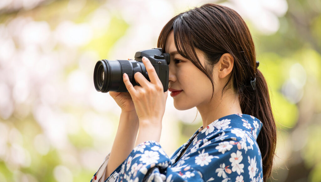 カメラのファインダーを覗く写真撮影する女性